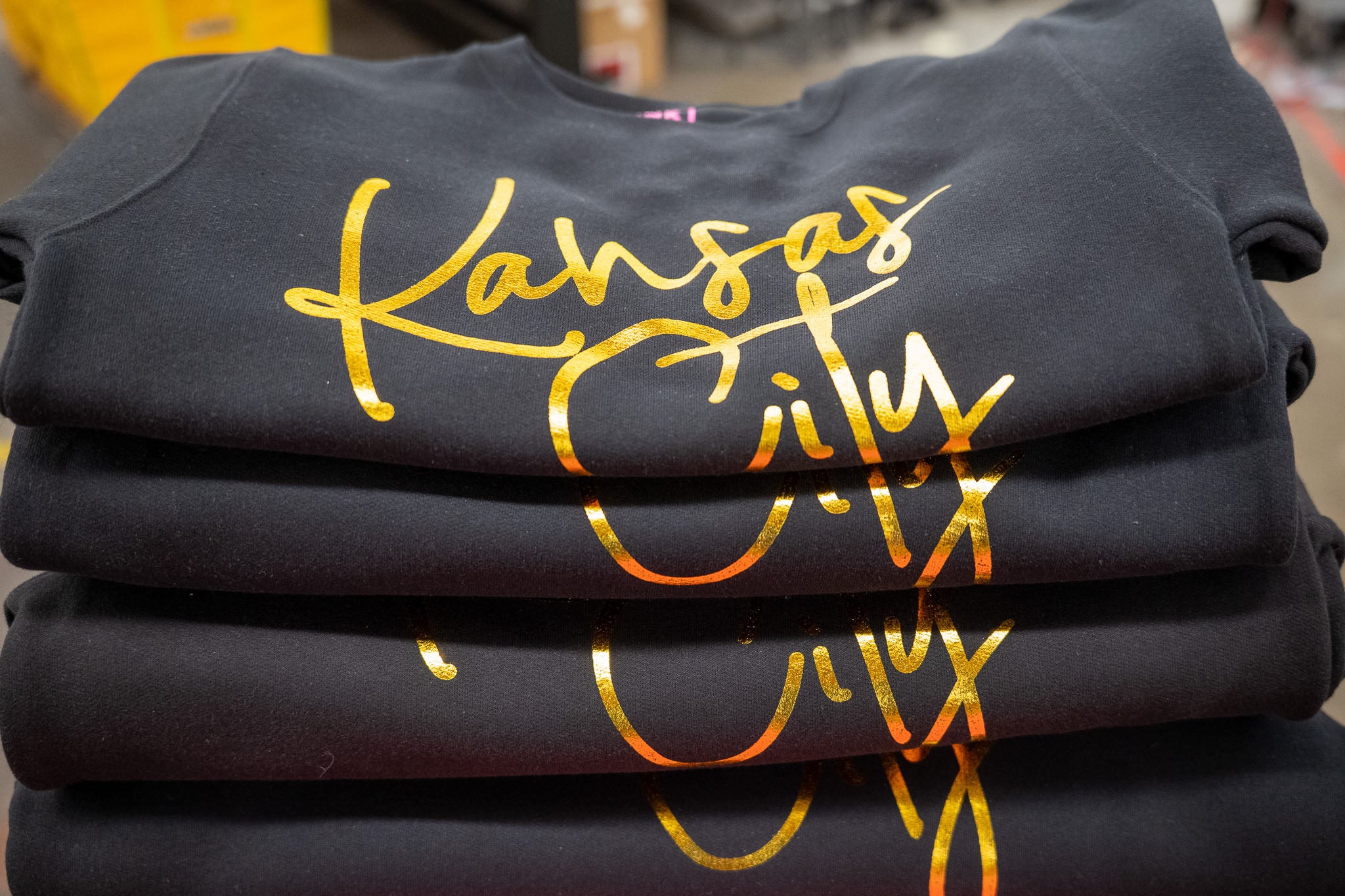 Stack of Black Shirts with Kansas City in Gold Foil on the front