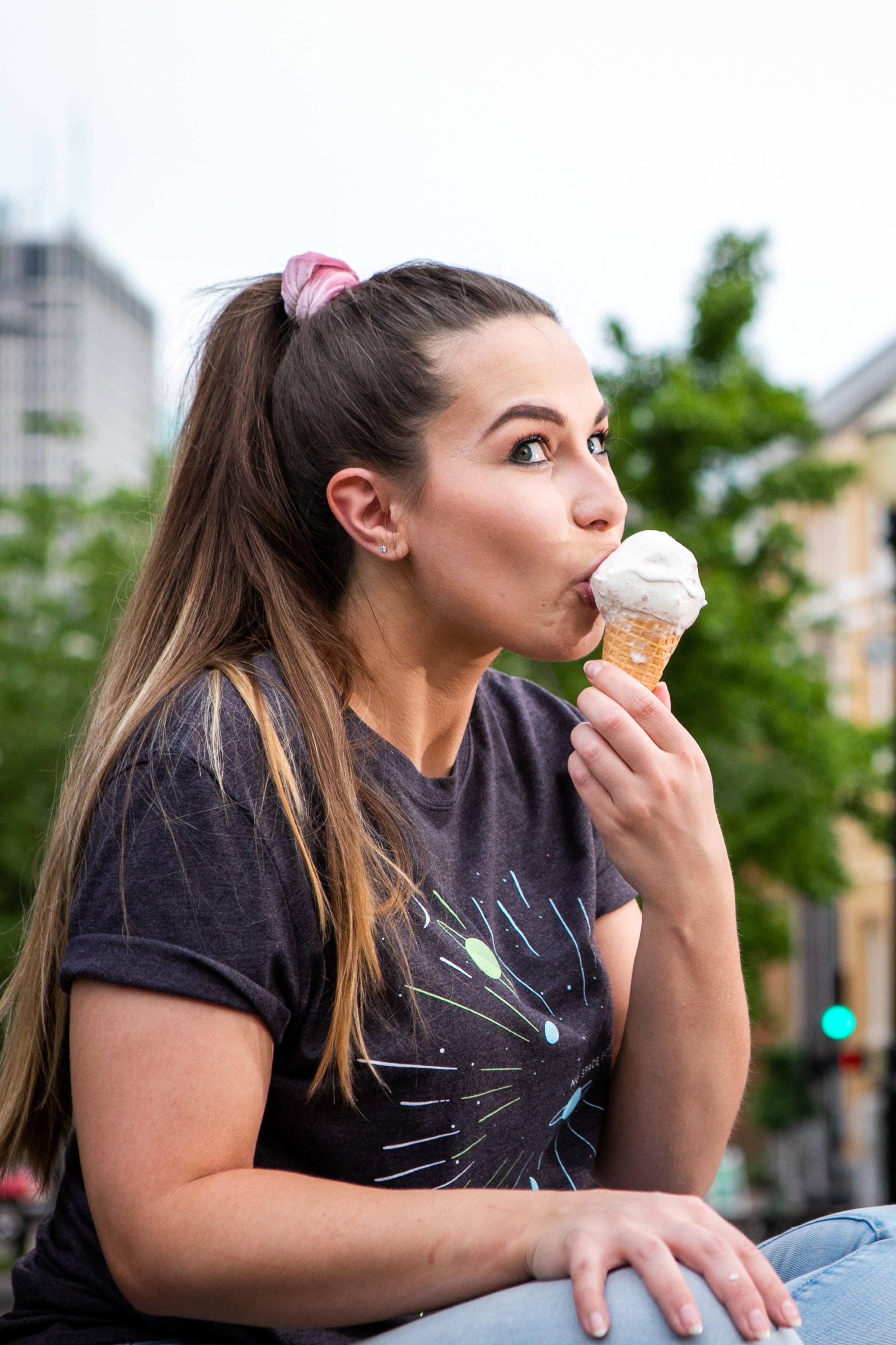 Female Model wearing GOEX No Space for Waste Graphic Tee and eating Ice Cream