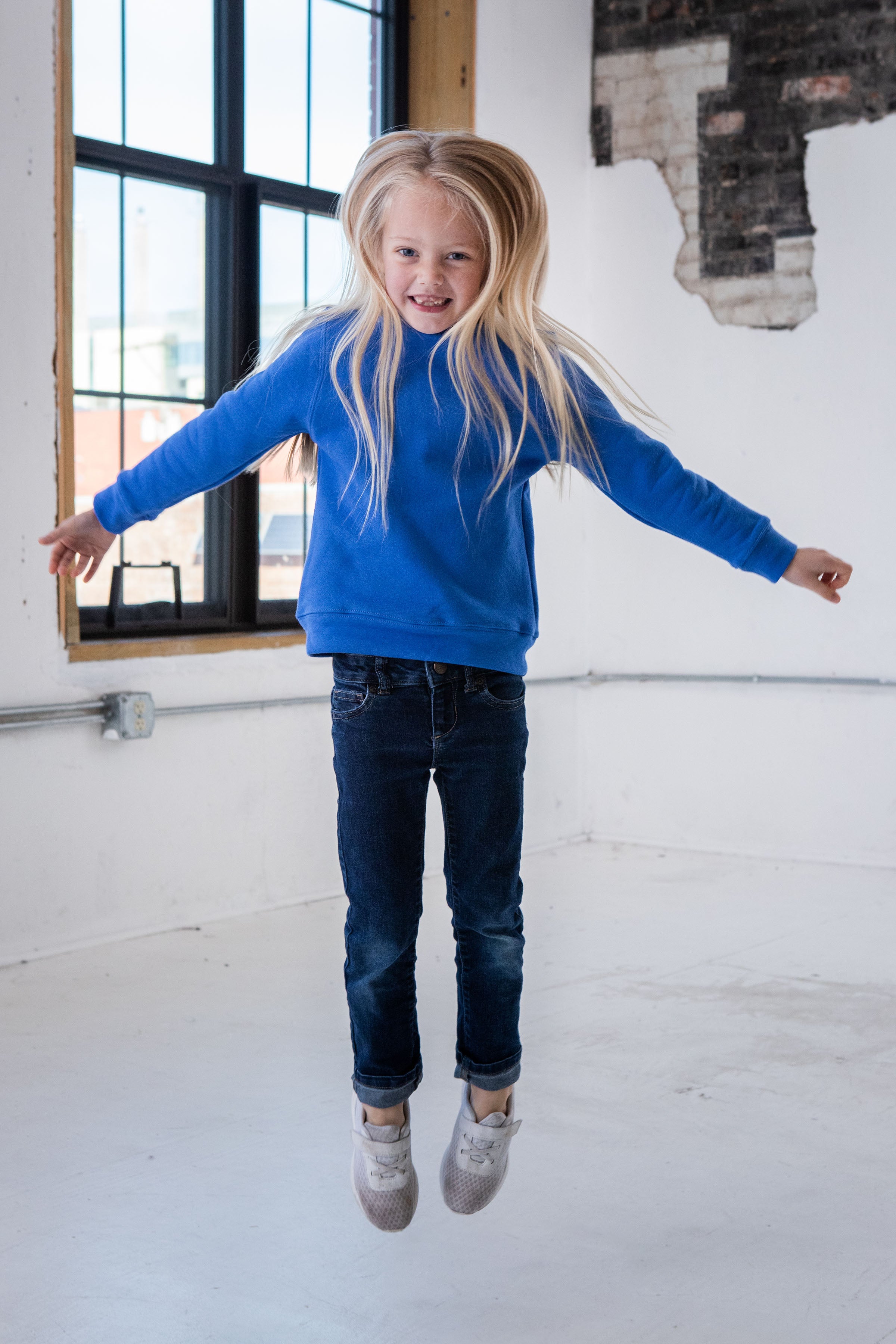 Girl Model wearing GOEX Youth Fleece Crew in Royal and Jumping