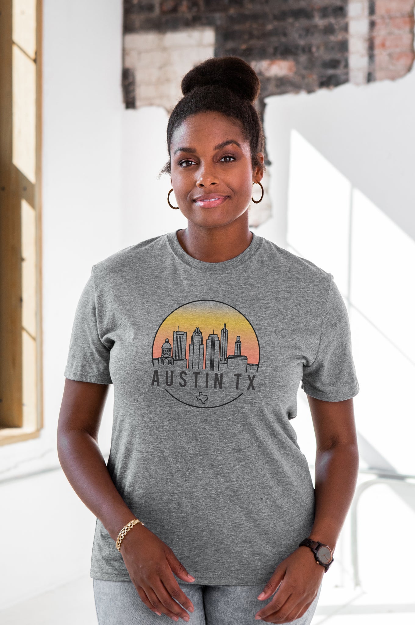 Female Model wearing GOEX Unisex and Men's Austin Skyline Eco Triblend Graphic Tee in Heather Grey