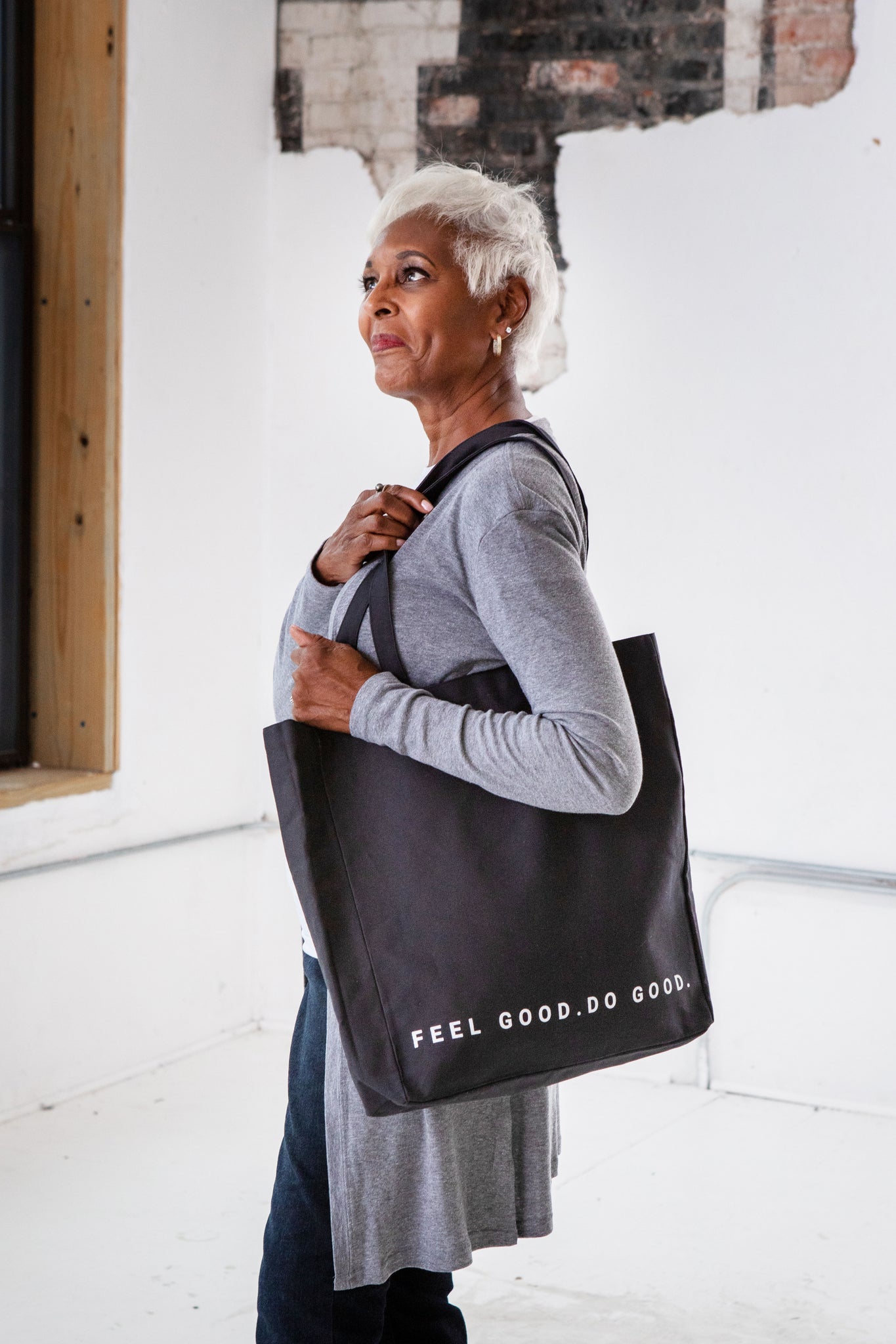 Female Model carrying GOEX Feel Good Do Good Black Tote Bag