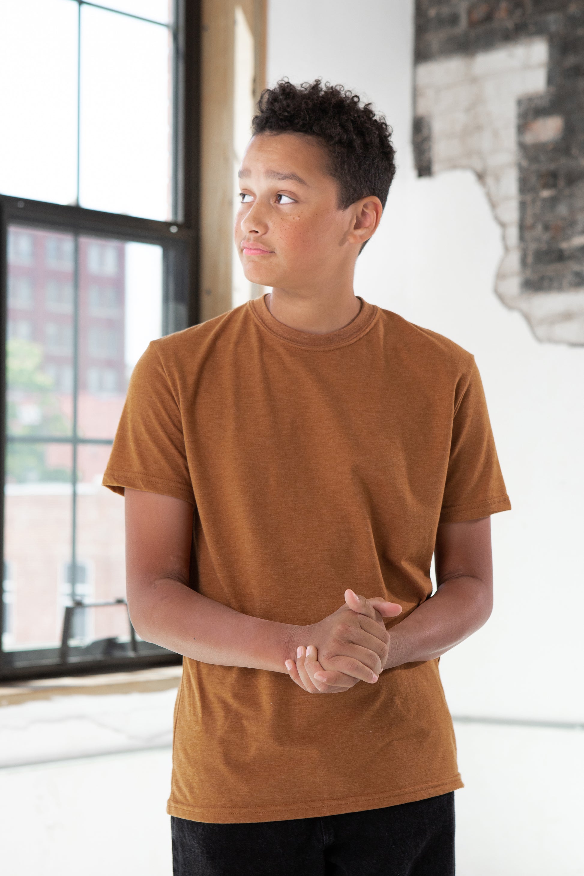 Boy Model wearing GOEX Youth Eco Triblend Tee in Amber
