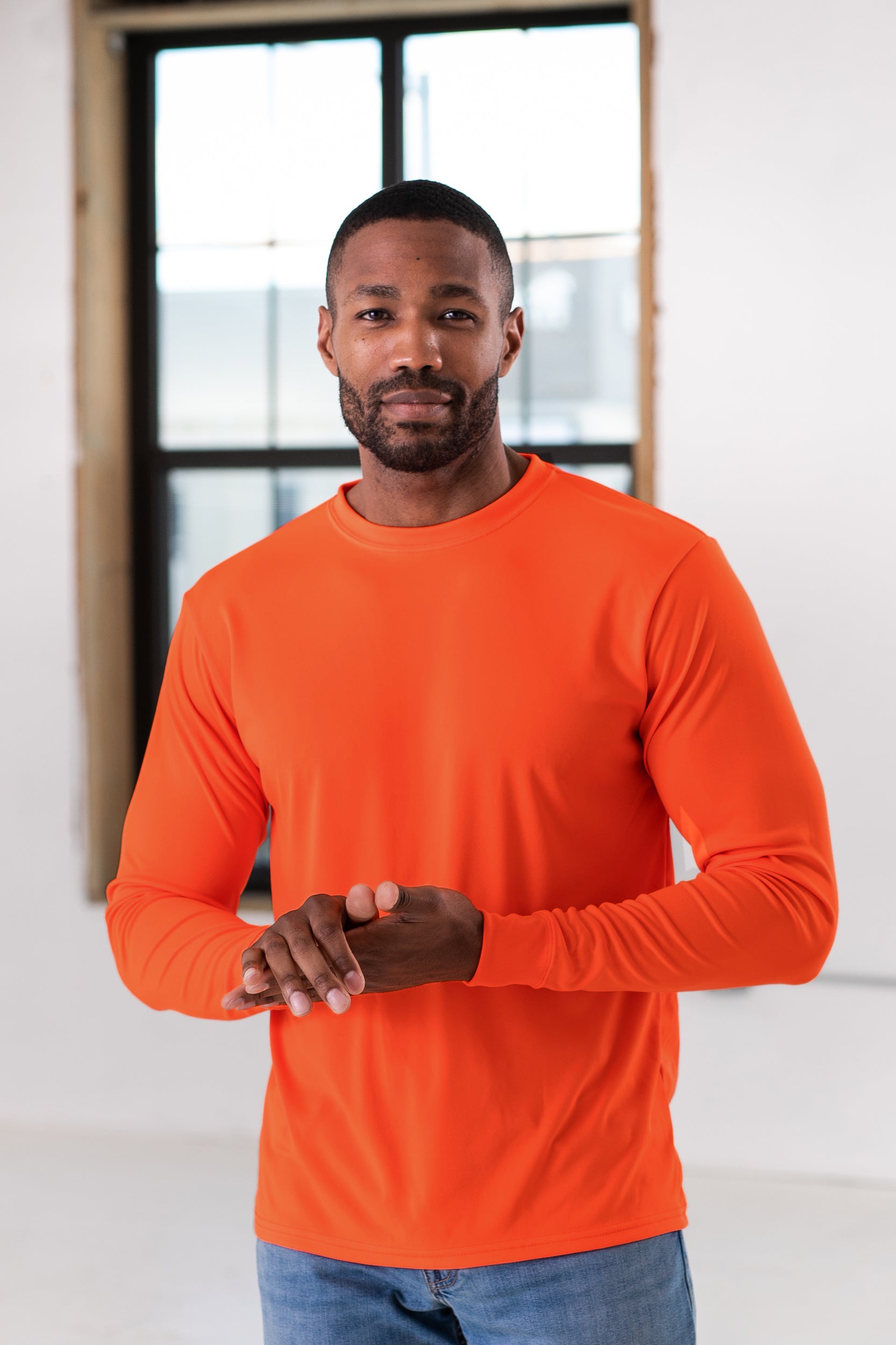 Male Model wearing GOEX Unisex and Men's Eco Poly LS Tee in Neon Orange